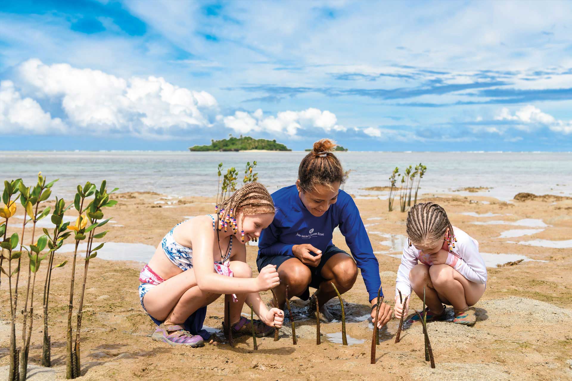 Children with a resident Marine Biologist planting mangrove seedlings as part of the highly developed sustainability programmes at Jean-Michel Cousteau Resort Fiji, an eco-friendly resort.