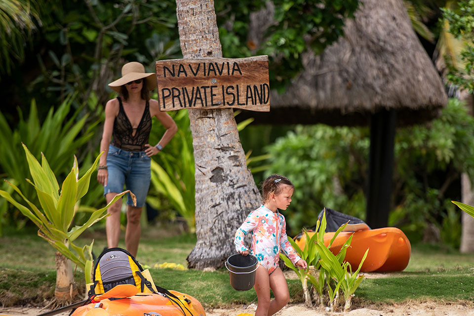 Image shows a mother spending time with her daughter busy at play at the beach. Tiny explorers also love Kids Bula Club, while grandparents and parents reconnect.