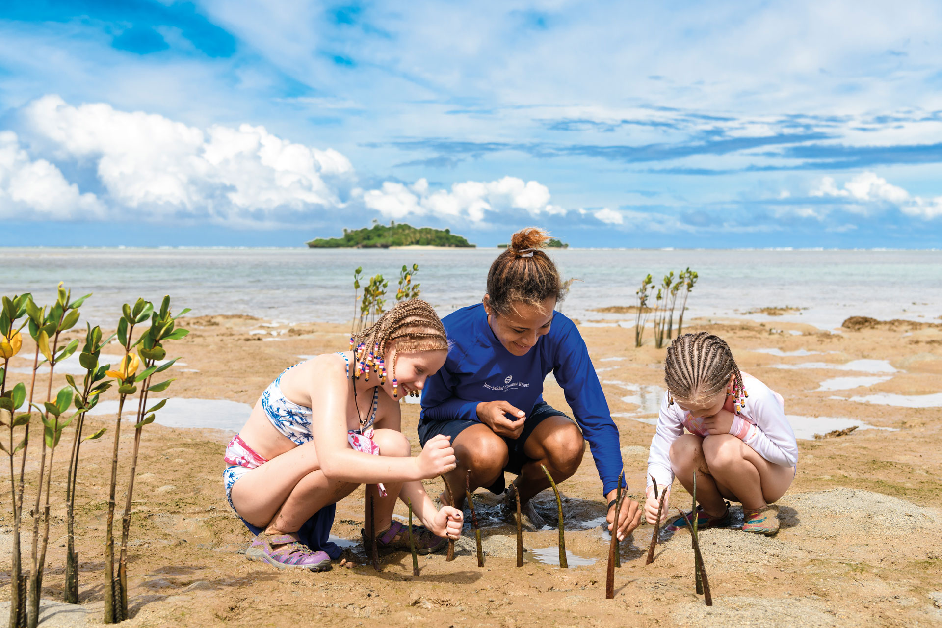 Children with a resident Marine Biologist planting mangrove seedlings as part of Kids Eco-Programmes at Jean-Michel Cousteau Resort Fiji, an all-inclusive family resort in Fiji.