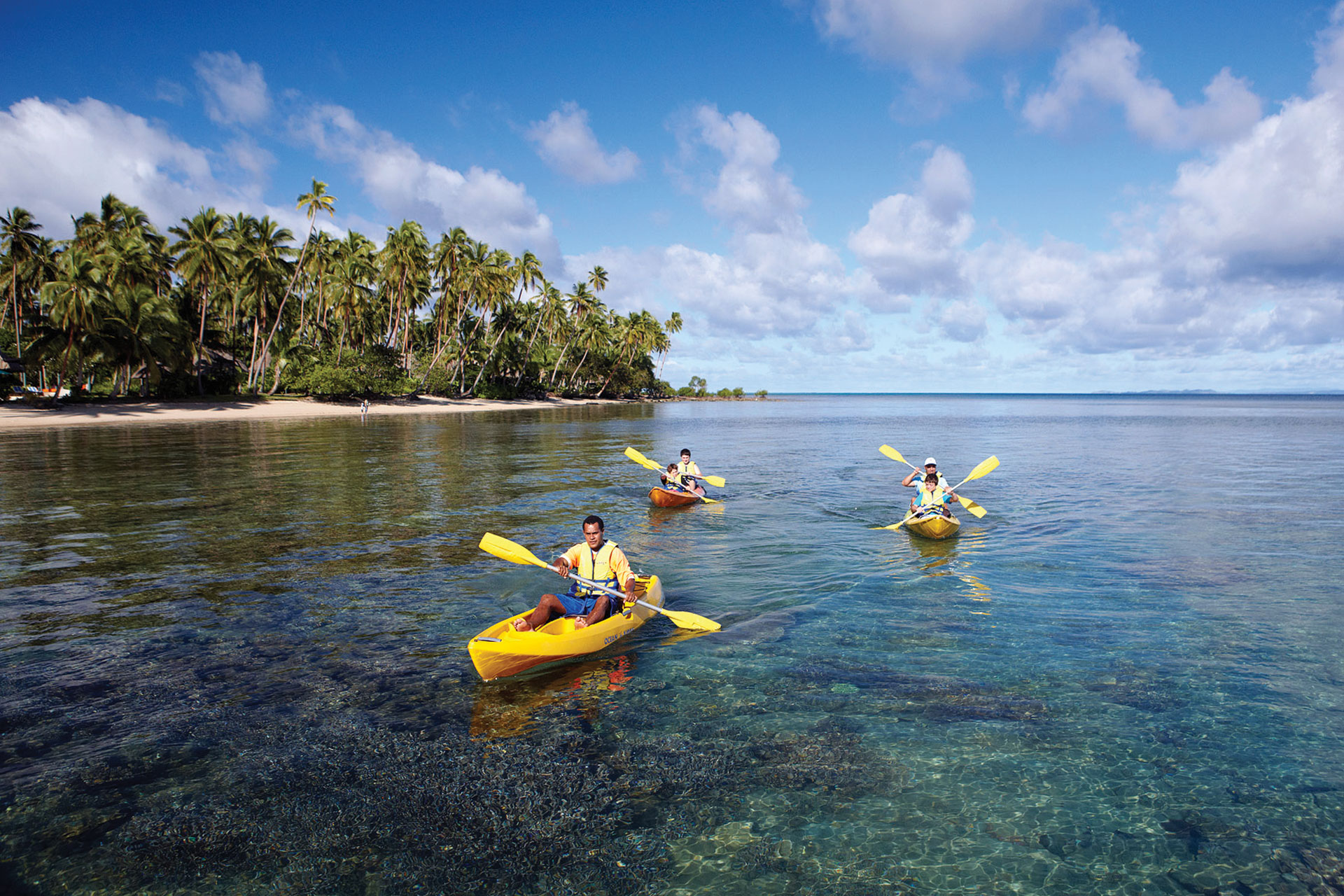 Water Activities. Image shows a family kayaking following a staff.